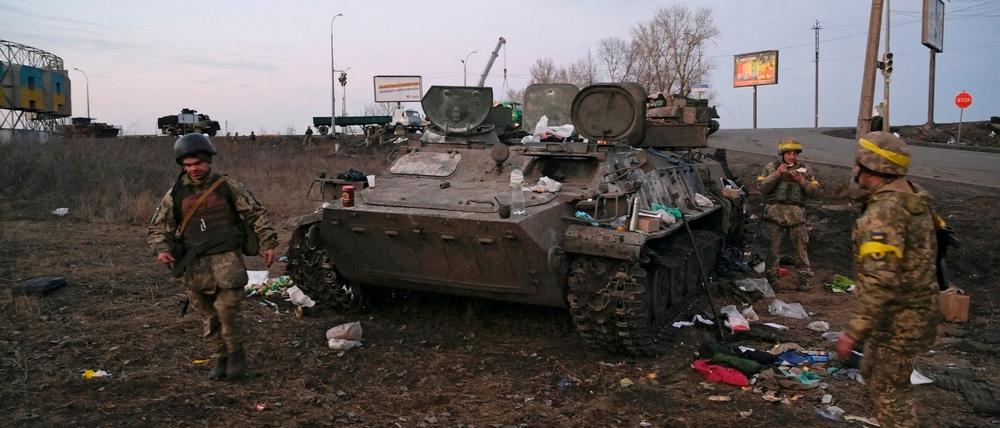 Ukrainische Soldaten stehen neben einem zerstörten gepanzerten Fahrzeug, das angeblich der russischen Armee gehört, außerhalb von Charkiw (Archivbild).