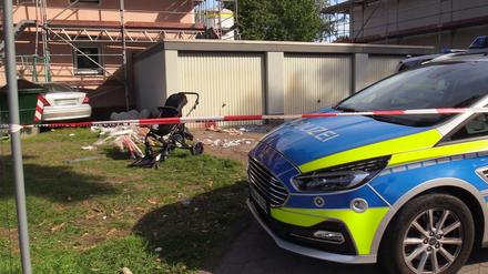 Ein Auto (links hinten) steht an einem Haus, nachdem der Fahrer zuvor seine Frau und sein Kind angefahren hatte. 