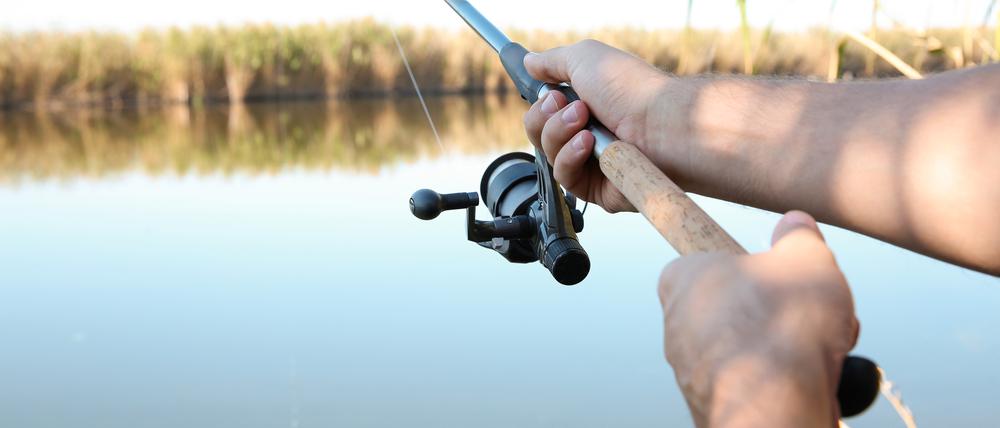 Man fishing alone at riverside on sunny day, closeup xkwx activity,adult,alone,angler,background,catch,closeup,copy,day,equipment,fish,fisherman,fishery,fishing,fun,gear,hand,hobby,holding,lake,landscape,leisure,lifestyle,line,male,man,modern,nature,outdoors,person,pond,recreation,reel,relax,rest,river,riverside,rod,season,shore,space,spinning,sport,summer,sunny,text,tool,view,water,weekend