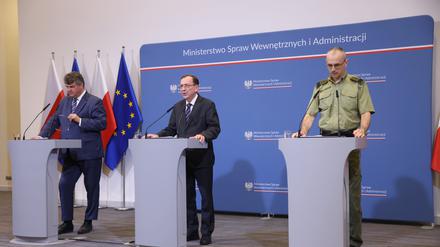 Mariusz Kaminski (M),  Minister für Innere Angelegenheiten und Verwaltung von Polen, Maciej Wasik (l), stellvertretender Minister für innere Angelegenheiten und Verwaltung, und Generalmajor Tomasz Praga (r) der Oberbefehlshaber des Grenzschutzes, sprechen während einer Pressekonferenz im Innenministerium.