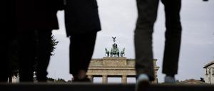 01.10.2023, Berlin: Passanten gehen vor dem Brandenburger Tor am Pariser Platz vorbei. Foto: Carsten Koall/dpa +++ dpa-Bildfunk +++