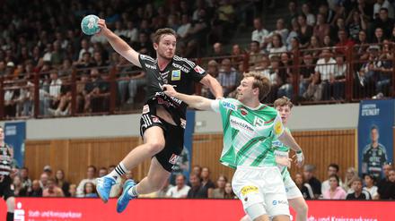 Mathias Gidsel (r.) von den Füchsen kämpft mit Jonathan Svensson (HC Erlangen) um den Einzug ins Achtelfinale.