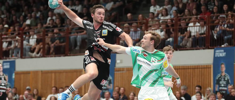 Mathias Gidsel (r.) von den Füchsen kämpft mit Jonathan Svensson (HC Erlangen) um den Einzug ins Achtelfinale.