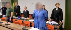 04.10.2023, Bayern, München: Die Angeklagte Andrea Tandler (3.v.r) steht zu Prozessbeginn an ihrem Platz im Gerichtssaal vor ihren beiden Anwältinnen Cheyenne Blum (2.v.r) und Sabine Stetter (r).