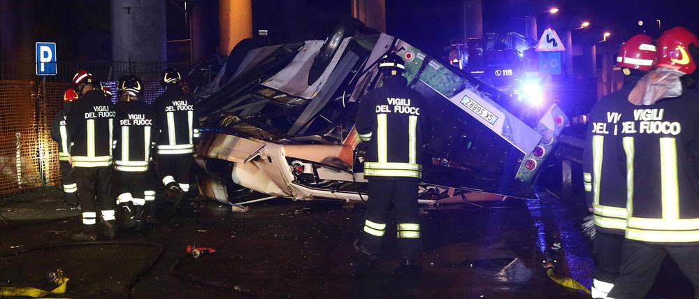 Feuerwehrleute versuchen, Opfer aus dem zerstörten Bus zu bergen. 