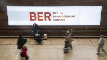 Reisende gehen durch das Terminal im Flughafen BER.