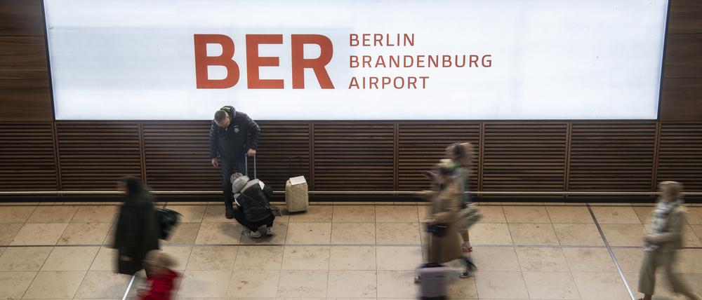 Reisende gehen durch das Terminal im Flughafen BER.