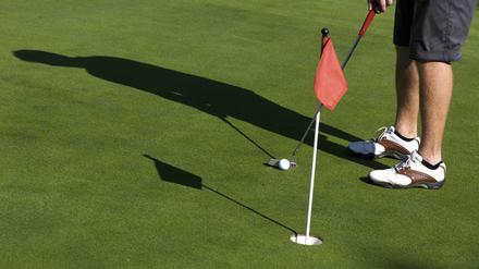 Ein Hobbygolfer trainiert auf dem Grün des Golfclubs Wannsee in Berlin einen Putt.