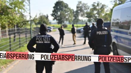 Einsatzkräfte der Polizei stehen hinter einer Polizeiabsperrung (Symbolbild)