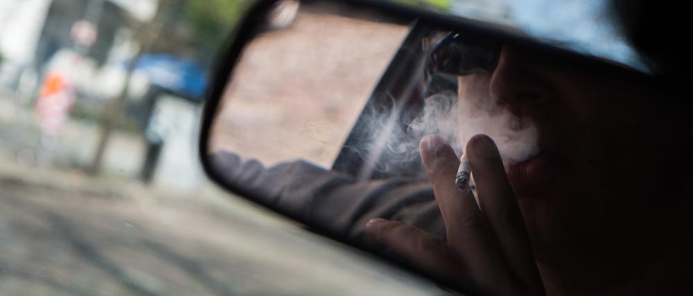 Eine Person raucht im Auto (Symbolbild). 