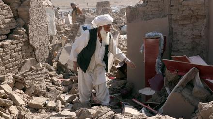 Ein Mann steht in Afghanistan den Trümmern seines Hauses.