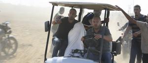 Palästinenser transportieren einen gefangenen israelischen Zivilisten aus dem Kfar Azza Kibbuz.