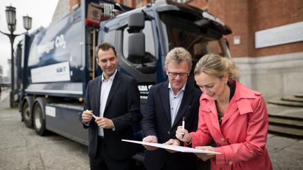 Alba-Chef Robert Arbter, Roger Alm von Volvo und Verkehrssenatorin Manja Schreiner unterschreiben symbolisch einen Kaufvertrag. 