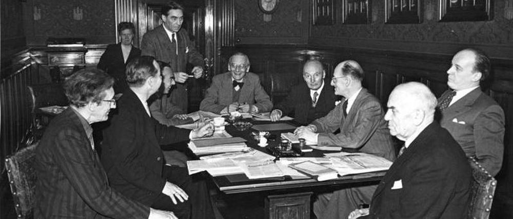 Illus-dpd
Pen-Tagung in Hamburg.
Das "Pen-Zentrum Deutschland" - die im November 1948 gebildete Gruppe des internationalen PEN - trat am 12-4-49 in Hamburg zu einer ersten Tagung zusammen.
Unser Bild zeigt die erste Arbeitssitzung im Kleinen Sitzungssaal des Hamburger Rathauses. V.r.n.l. um den Tisch sitzend: Prof. [Herbert] Friedmann - Dolf Sternberger - Axel Eggebrecht - Herbert Eulenberg - Hermann Kasack - Rudolf Schneider-Schelde (stehend) - Erich Kästner - Hanns Hennry Jahnn und Ernst Penzoldt.
3090-49