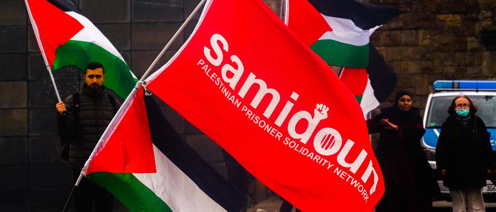Palästina- und Samidoun-Fahnen bei einer Demonstration.