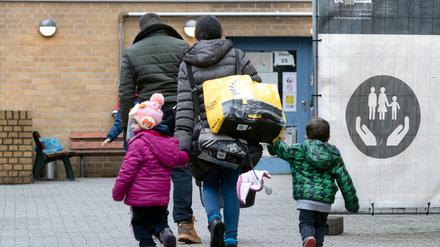 Ein Flüchtling geht mit seiner Familie auf dem Gelände der Erstaufnahmeeinrichtung des Landesamtes für Flüchtlingsangelegenheiten (LAF) in Reinickendorf. 