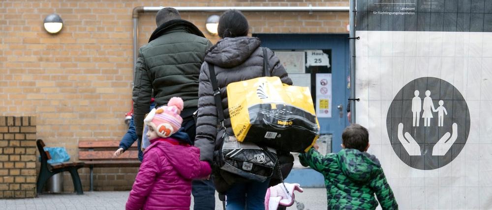 Ein Flüchtling geht mit seiner Familie auf dem Gelände der Erstaufnahmeeinrichtung des Landesamtes für Flüchtlingsangelegenheiten (LAF) in Reinickendorf.