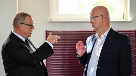 Michael Stübgen (l., CDU), Brandenburger Minister des Innern und für Kommunales, und Stephan Loge (r., SPD), Landrat des Kreises Dahme-Spreewald, unterhalten sich vor Beginn der Konferenz der Landräte und Oberbürgermeister.