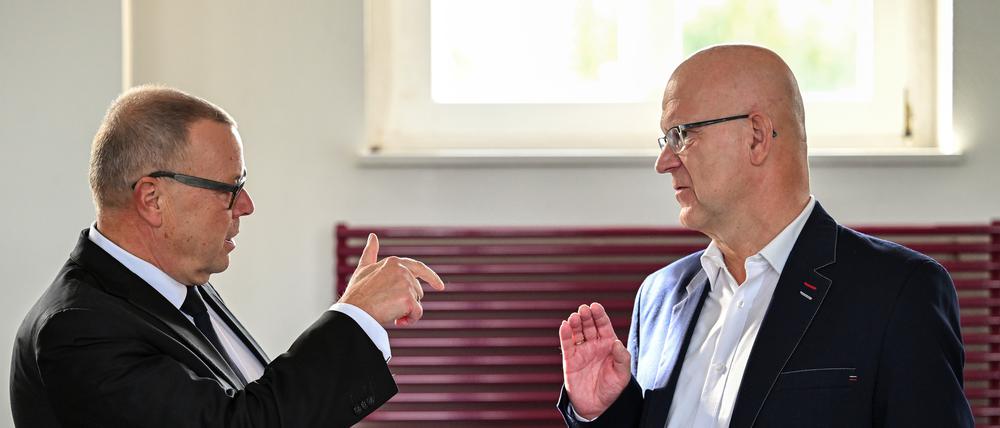 Michael Stübgen (l., CDU), Brandenburger Minister des Innern und für Kommunales, und Stephan Loge (r., SPD), Landrat des Kreises Dahme-Spreewald, unterhalten sich vor Beginn der Konferenz der Landräte und Oberbürgermeister.