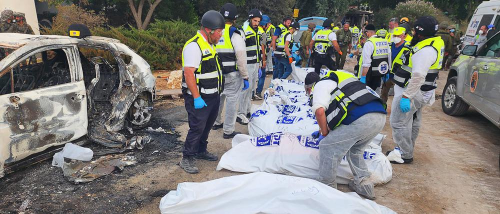 Dieses vom Rettungsdienst Zaka zur Verfügung gestellte Foto zeigt Mitarbeiter des Rettungsdiensts Zaka neben Leichensäcken und verbannten Autos in einem Kibbuz im Süden Israels nach dem Massaker der islamistischen Hamas.
