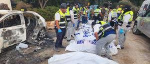 Dieses vom Rettungsdienst Zaka zur Verfügung gestellte Foto zeigt Mitarbeiter des Rettungsdiensts Zaka neben Leichensäcken und verbannten Autos in einem Kibbuz im Süden Israels nach dem Massaker der islamistischen Hamas. 