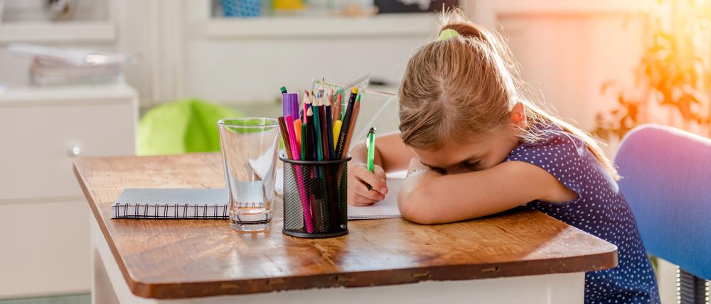 Girl in blue shirt having problem with concentration to finish home work