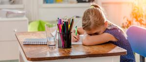 Girl in blue shirt having problem with concentration to finish home work