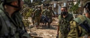 Israelische Streitkräfte bergen Leichen von israelischen Bewohnern aus einem zerstörten Haus. 