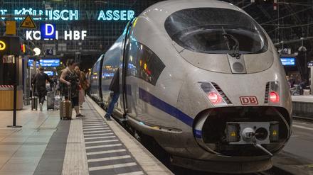 Reisende steigen auf einem Bahnsteig im Kölner Hauptbahnhof in einen ICE der Deutschen Bahn.