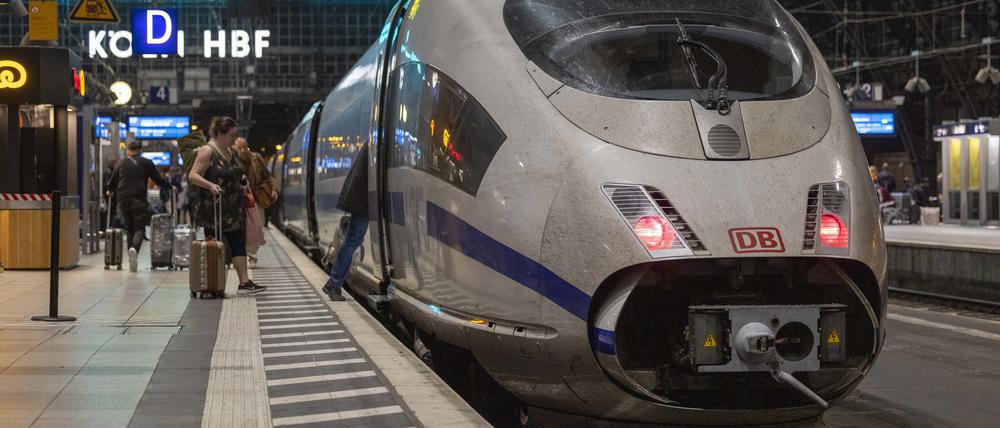 Reisende steigen auf einem Bahnsteig im Kölner Hauptbahnhof in einen ICE der Deutschen Bahn.