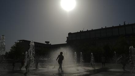 13.08.2021, Spanien, Pamplona: Kinder springen im Wasser eines Brunnens. Die Temperaturen in Spanien kletterten deutlich über die 40-Grad-Marke. Foto: Alvaro Barrientos/AP/dpa +++ dpa-Bildfunk +++