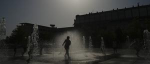 13.08.2021, Spanien, Pamplona: Kinder springen im Wasser eines Brunnens. Die Temperaturen in Spanien kletterten deutlich über die 40-Grad-Marke. Foto: Alvaro Barrientos/AP/dpa +++ dpa-Bildfunk +++