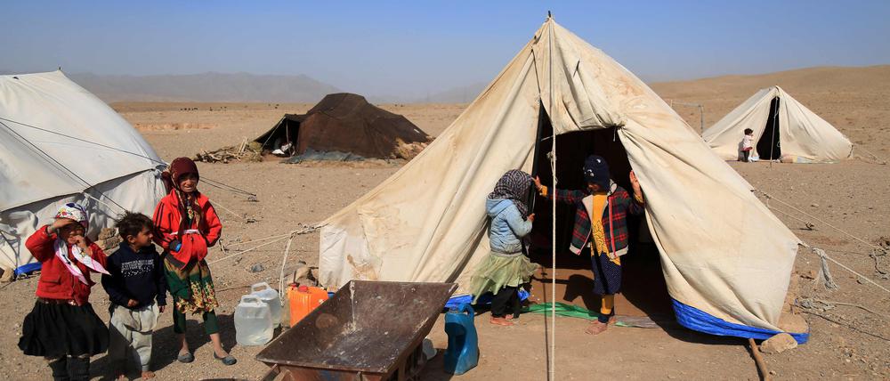 Afghanische Kinder stehen am 15. Oktober 2023 vor ihren Notzelten in einem erdbebengeschädigten Gebiet des Distrikts Injil in der Provinz Herat. 