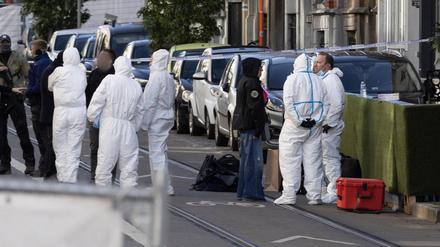 Polizisten und Forensiker stehen nach dem Anschlag in Brüssel in einer abgesperrten Straße am Tatort.