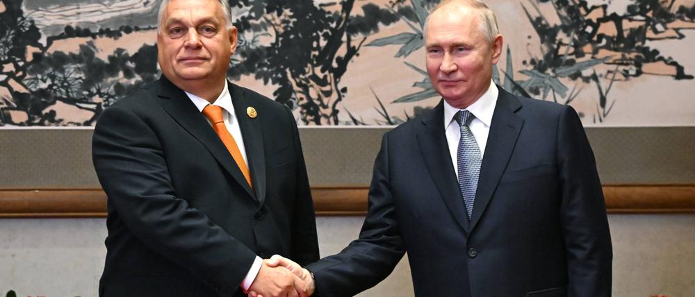 Der ungarische Ministerpräsident Viktor Orbán und der russische Präsident Wladimir Putin schütteln die Hand vor ihrem Treffen in Peking.