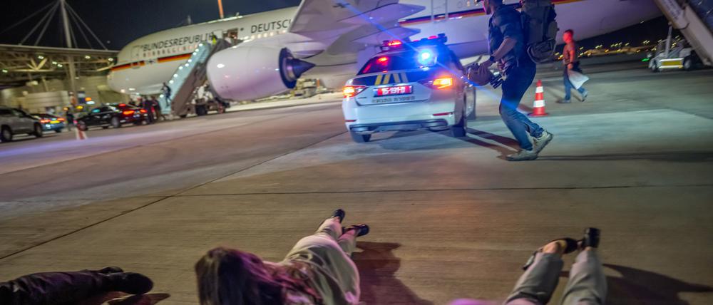 Personen liegen auf dem Flughafen von Tel Aviv vor dem Luftwaffen-Airbus von Bundeskanzler Scholz auf dem Boden. Die Delegation des Bundeskanzlers hatte vor dem Abflug nach Kairo wegen eines Raketenalarms schlagartig das Flugzeug verlassen müssen.