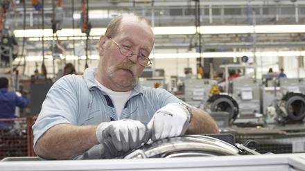 Manfred Klato (53) bei der Endmontage von Waschmaschinen und Wäschetrocknern der Firma Miele in Gütersloh.