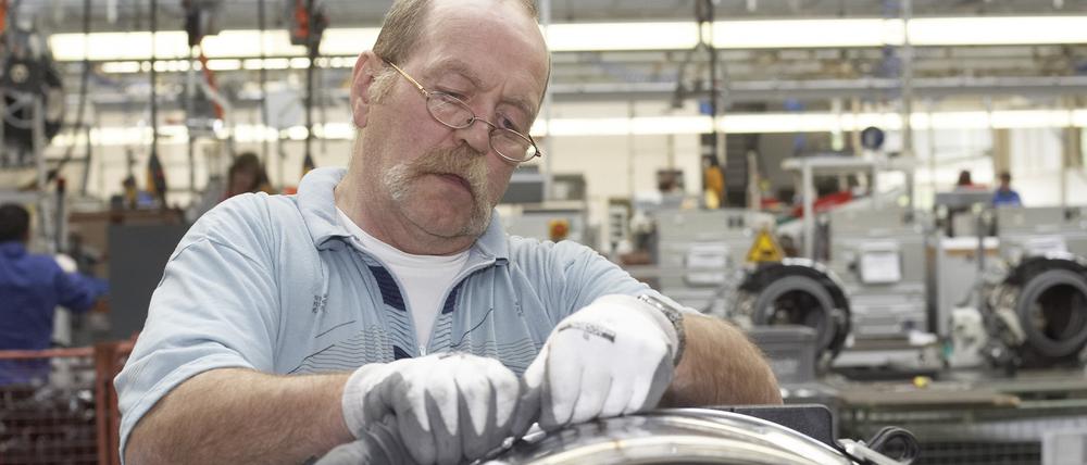 Manfred Klato (53) bei der Endmontage von Waschmaschinen und Wäschetrocknern der Firma Miele in Gütersloh.
