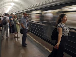 Eine Frau im Windzug einer einfahrenden U-Bahn in der russischen Hauptstadt.