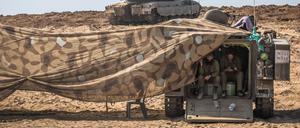 Israelische Soldaten gehen in einem Militärfahrzeug in dem Gebiet in der Nähe des Kibbutz Be’eri in Deckung.