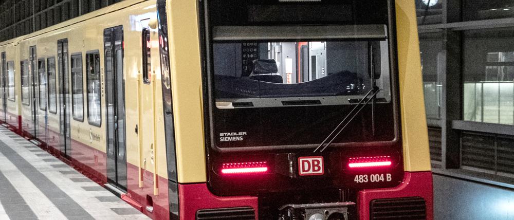 Eine S-Bahn fährt in der Nacht durch einen Bahnhof.