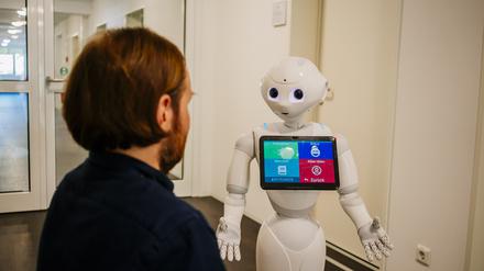 Robert Ranisch, Juniorprofessor für Medizinische Ethik mit Schwerpunkt auf Digitalisierung an der Fakultät für Gesundheitswissenschaften der Universität Potsdam, mit einem Pflegeroboter.