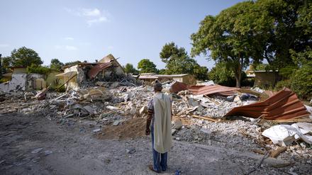 Ein israelischer Mann, der einen Gebetsschal trägt, betet neben Häusern, die durch die Hamas zerstört wurden. 