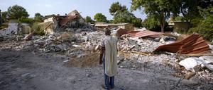 Ein israelischer Mann, der einen Gebetsschal trägt, betet neben Häusern, die durch die Hamas zerstört wurden. 
