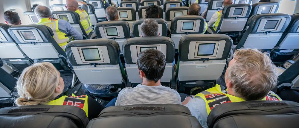 Zwei Polizeibeamte eskortieren einen Afghanen auf dem Flug von Leipzig nach Kabul in einem Charterflugzeug.