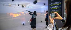 Eine Frau benutzt einen XR-Schießsimulator auf der Seoul International Aerospace and Defense Exhibition (ADEX) in Seongnam, südlich von Seoul, am 18. Oktober 2023.