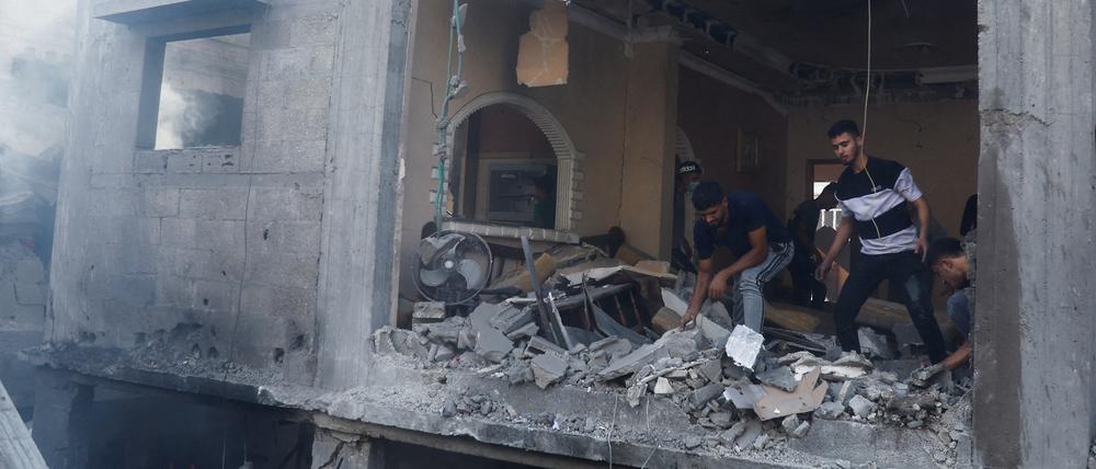 Palestinians inspect the site of an Israeli strike on a house, in Khan Younis, in the southern Gaza Strip, October 24, 2023.