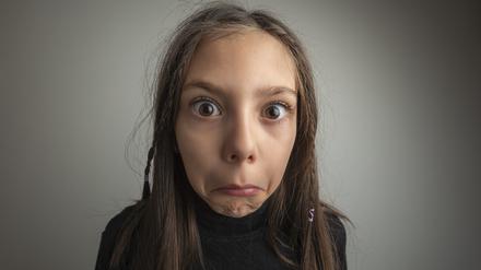 A girl with an expression of disbelief on her face.Studio shot