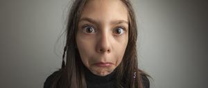 A girl with an expression of disbelief on her face.Studio shot