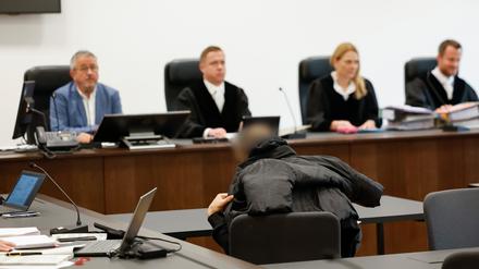 Der angeklagte Ex-Mitarbeiter eines Sicherheitsdienstes (M) sitzt zu Prozessbeginn im Landgericht.